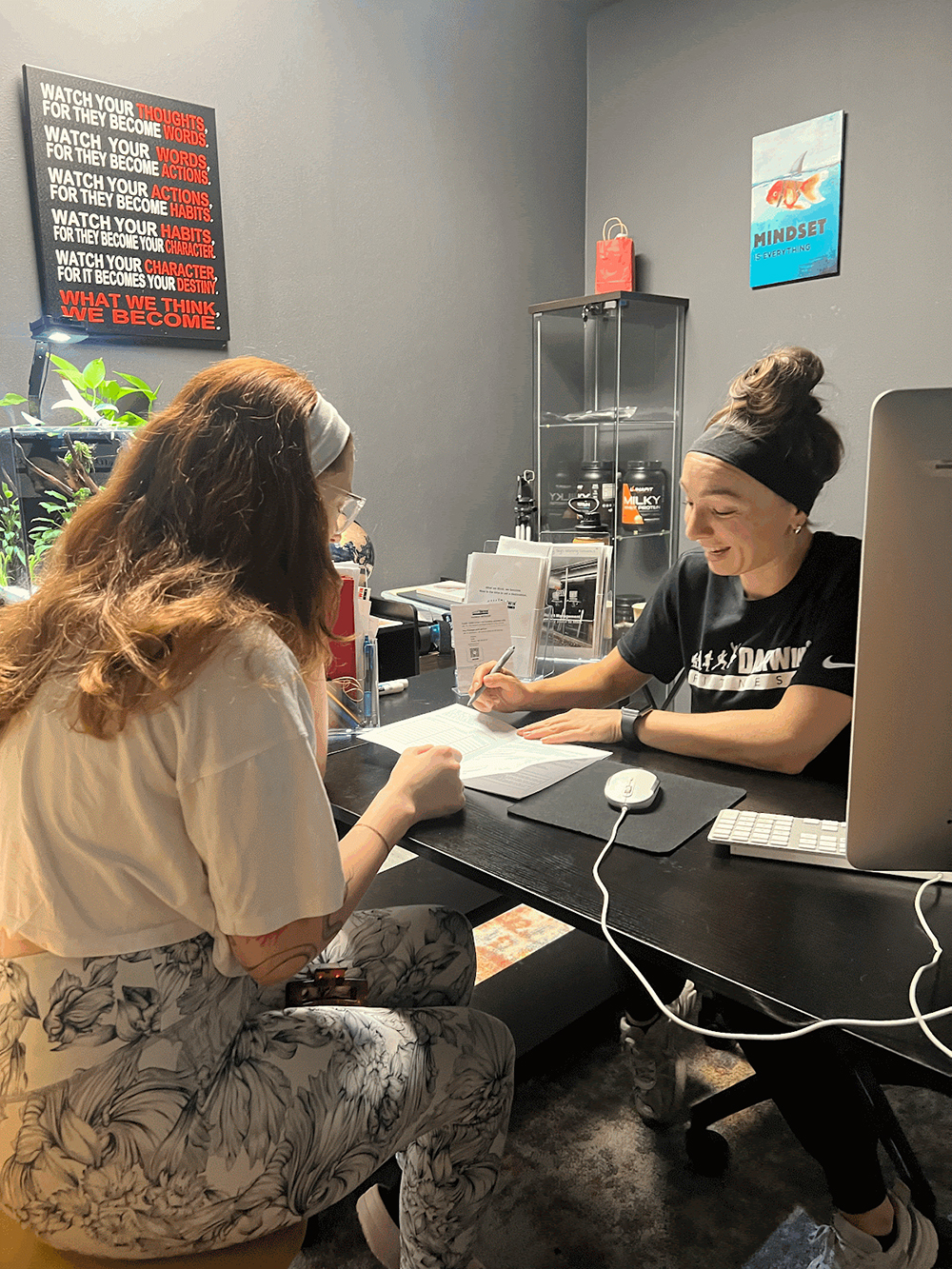 a certified personal trainer and nutrition coach at darwin fitness reviewing scientific inbody body composition scan data with a client, discussing fat loss progress and metabolic health metrics in a private consultation setting